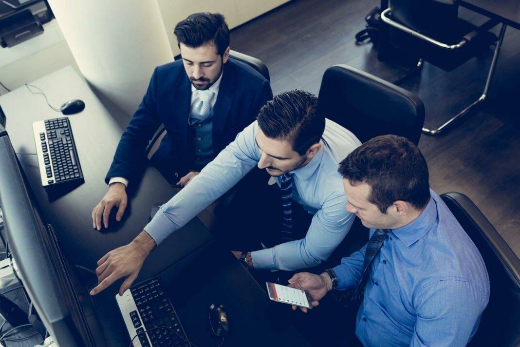 Business Team Analyzing Data On Computer.