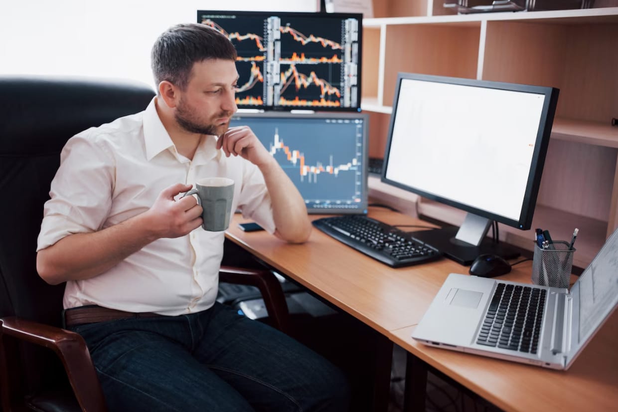 A day trader having coffee and concentrating on making trading decisions.